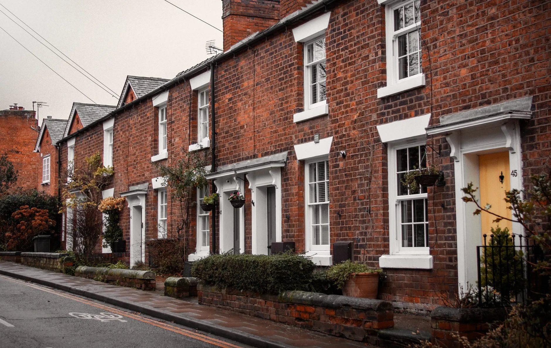 A terrace of red-brick Victorian houses with white sash windows
